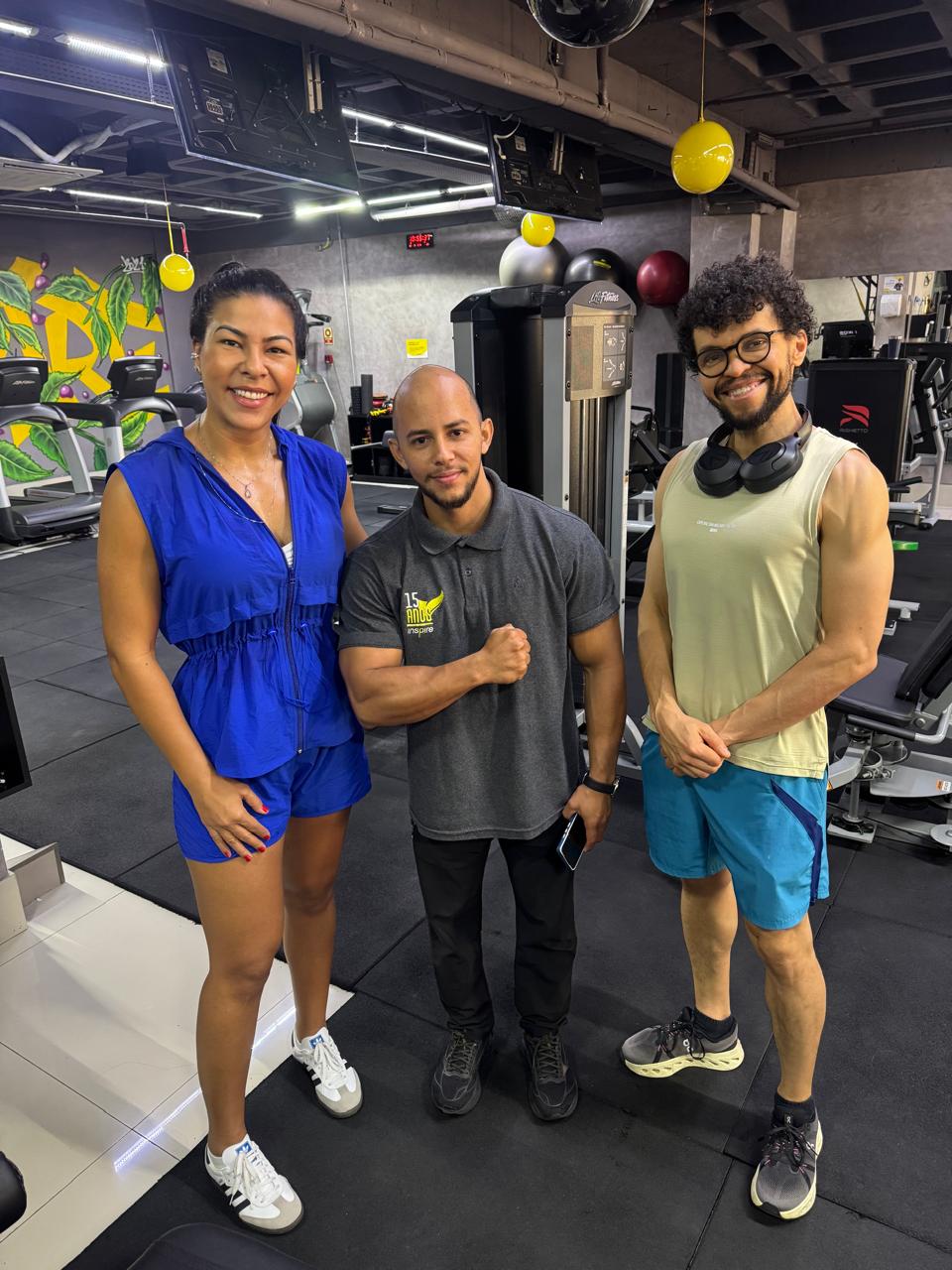Três pessoas sorrindo na área de equipamentos da Inspire